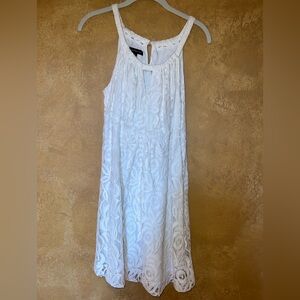 White lace dress with a little keyhole cut out in the front neckline.